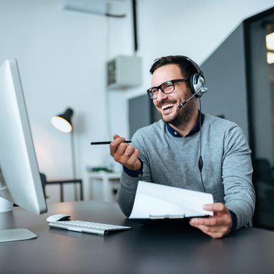 Handsome smiling man working at help desk.
